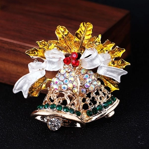 Christmas bell brooch with gold leaves and sparkling colorful rhinestones on dark background