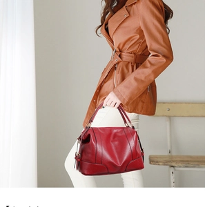 Detail of red pebbled leather Boston bag with contrast black stitching and metal zippers