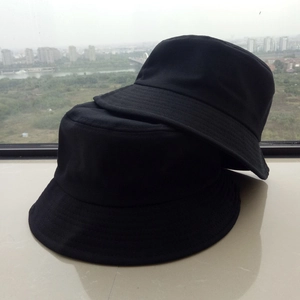 Close-up of stacked black cotton bucket hats showing fine stitching and durable fabric