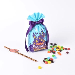 Blue Halloween candy gift bag with castle pattern and purple ribbon bow on white background