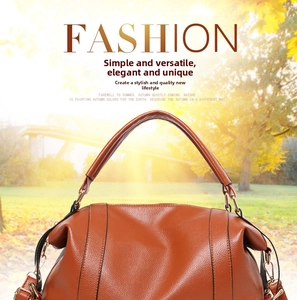Detail of caramel brown soft leather handbag featuring textured lychee grain and gold metal hardware