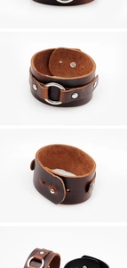Detail view of a wide vintage brown leather punk bracelet with silver metal ring and rivets