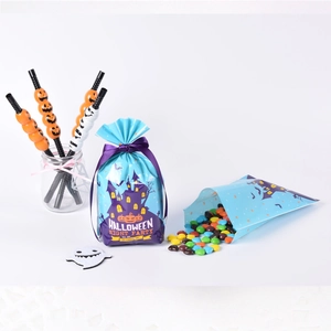 Blue Halloween cookie bags with purple ribbons, featuring pumpkins and bats for party treats