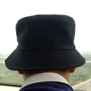 Rear view of a black cotton bucket hat showing the plain fabric and stitching detail