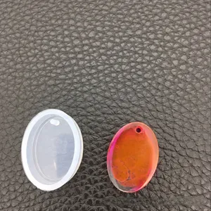 Detail der ovalen Silikonform und des fertigen Anhängers mit orangefarbenem Farbverlauf