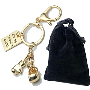 Golden boxing glove keychain with engraved metal tag and black velvet gift pouch