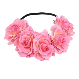 Detail of pink fabric roses on a black elastic headband for party styling