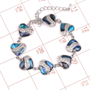 Vista detallada de pulsera de plata con forma de corazón e incrustaciones de abulón y filigrana