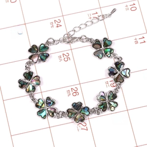 Detalle de pulsera de trébol plateada con incrustaciones de nácar de abulón y cierre