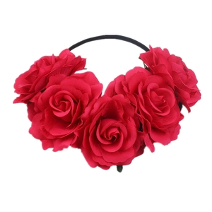 Close-up of six vibrant red fabric roses arranged on a slim bohemian headband