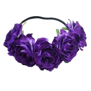Detail view of purple artificial roses on a black elastic headband for party styling