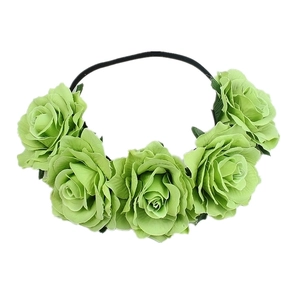 Macro detail of five green silk roses attached to a black elastic headband for festivals
