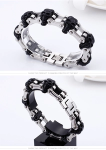 Macro view of biker style stainless steel chain bracelet with black skull design motifs