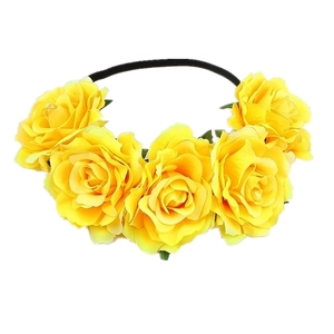 Detail of yellow fabric roses on a black elastic headband for festive parties