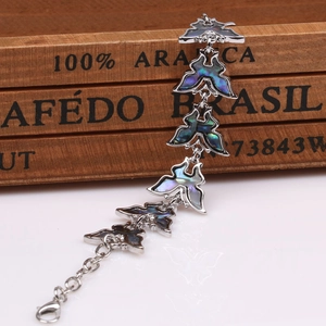 Detalle de pulsera de mariposa con incrustación de concha colorida y cierre de mosquetón