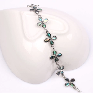 Detalle de pulsera de flores de nácar de abulón colorido con cadena plateada fina