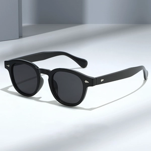 Lunettes de soleil ovales noires rétro avec rivets argentés dans un cadre minimaliste