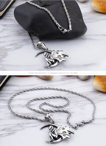 Detail of silver stainless steel angel sitting on moon pendant with twisted chain