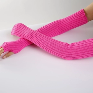Neon pink knitted arm warmers with thumb holes and ribbed texture for winter fashion
