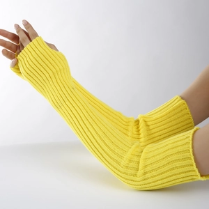 Detail view of yellow knitted arm warmers on model from wrist to upper arm
