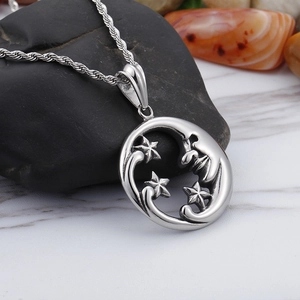 Minimalist silver stainless steel moon and stars pendant necklace on dark pebble