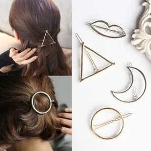Detailed views of gold geometric hair clips showing triangle and circle shapes on hair