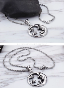 Detail view of crescent moon and stars round pendant necklace with rope chain on marble