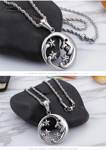 Detail of silver crescent moon and stars pendant on rope chain against marble background