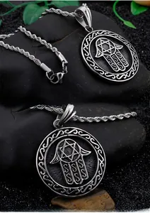 Detailed close-up of Hamsa Hand and Star of David pendant with a classic rope chain