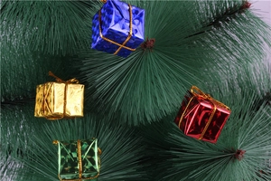 Close-up of colorful laser foam gift box ornaments hanging on Christmas tree branches