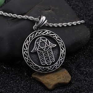 Silver Hamsa Hand pendant necklace with Star of David on professional dark stone background