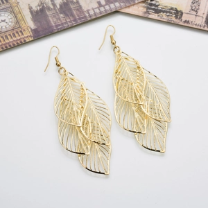 Bohemian gold layered hollow leaf earrings displayed on a vintage white background card