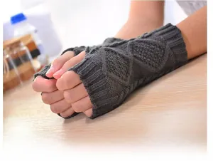 Detail of dark grey knit fingerless glove showing diamond cable stitch pattern texture