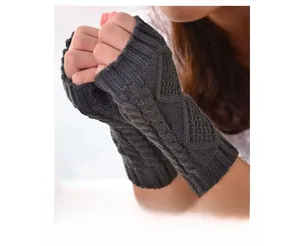 Detail of dark grey knitted fingerless gloves with a classic cable knit diamond pattern