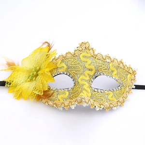 Detail of yellow lace masquerade mask with feathers, mesh flowers and sparkling rhinestones