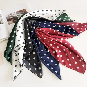 Polka dot silk-feel square scarves in multiple colors arranged on a white surface