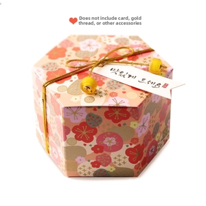 Detail of hexagonal gift box with colorful floral patterns and gold cord accents