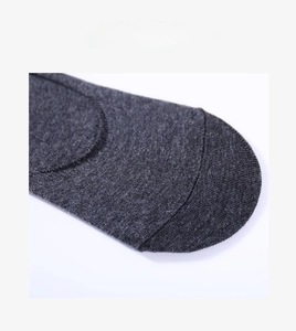 Gros plan de chaussettes en coton gris foncé montrant la couture plate aux orteils