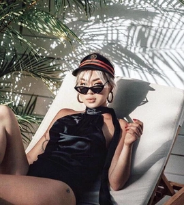 Close-up of black halter neck bodysuit with matte finish in a tropical setting