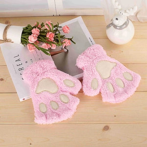 Detail of pink plush cat paw fingerless gloves with soft embroidery on wooden surface
