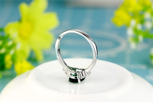 Macro detail of S925 silver ring featuring an emerald green zircon on ceramic base