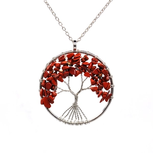 Close-up of handmade silver wire tree of life pendant with red natural stone chips