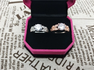 Detail of leaf design engagement rings with round zircon in a pink octagonal gift box