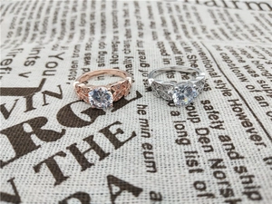 Detail of rose gold and silver leaf engagement rings with round zircon center stones