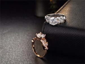 Detail view of leaf-shaped engagement rings in silver and rose gold with zircon stones