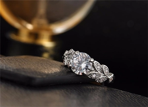 Macro detail of leaf-shaped engagement ring with round zircon in a four-prong setting