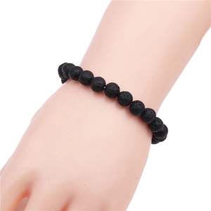 Detail of 8mm black lava stone beaded bracelet worn on wrist for a natural style