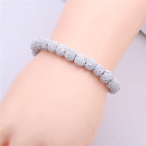 Close-up of 8mm grey volcanic lava rock bead bracelet worn on wrist with natural stone texture