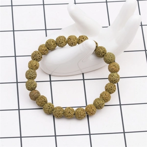 Detailed close-up of an 8mm olive green lava stone beaded bracelet on a hand display