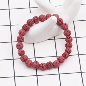 Detail of 8mm red volcanic lava stone beads on a white ceramic hand model